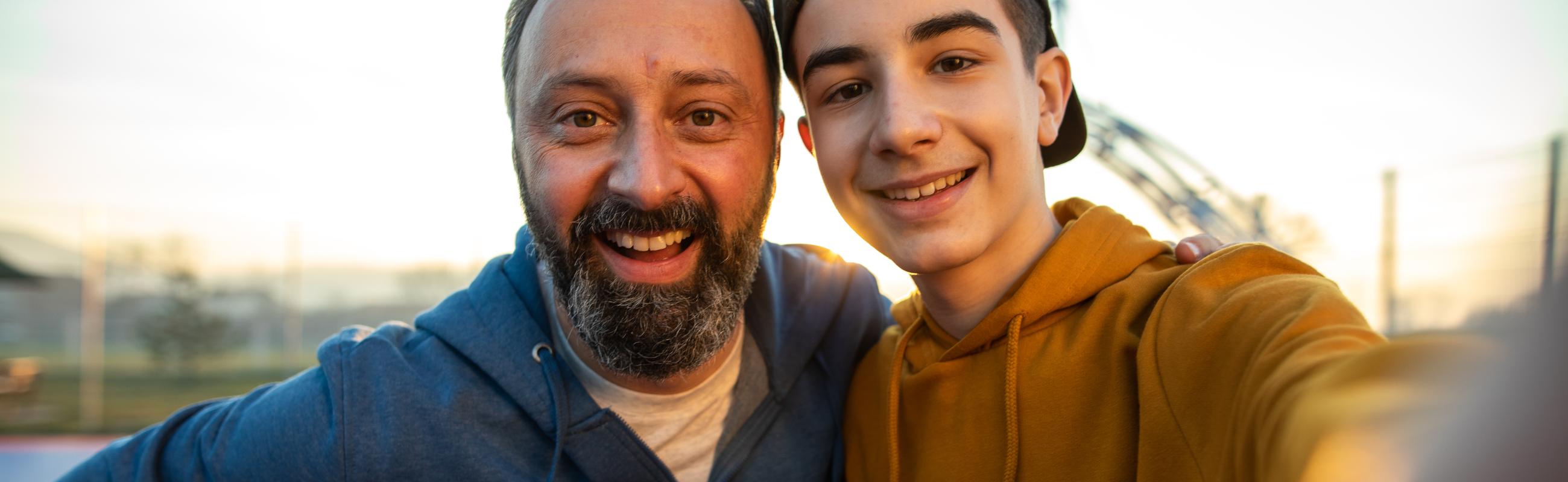 a father and son take a selfie while playing basketball