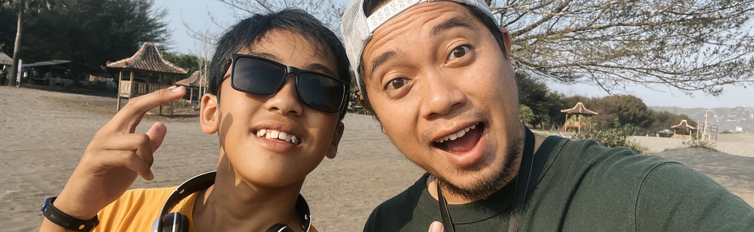 a father and son pose while taking a selfie