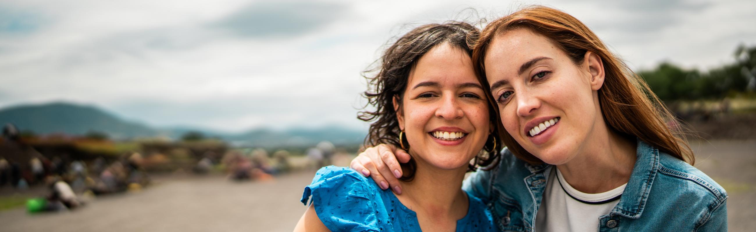 mother and daughter with arms around each other outside a campground